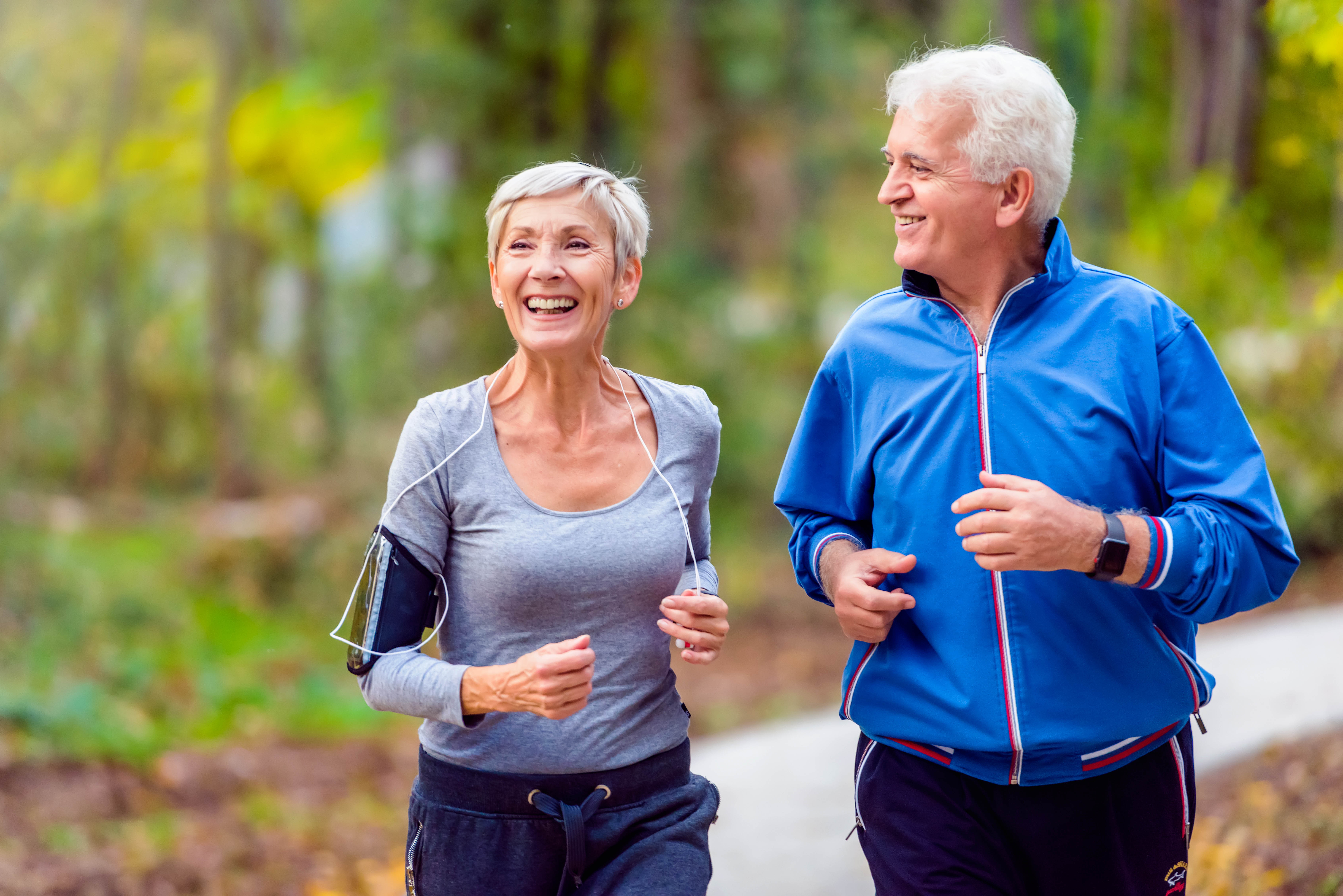 Older couple jogging out in a park